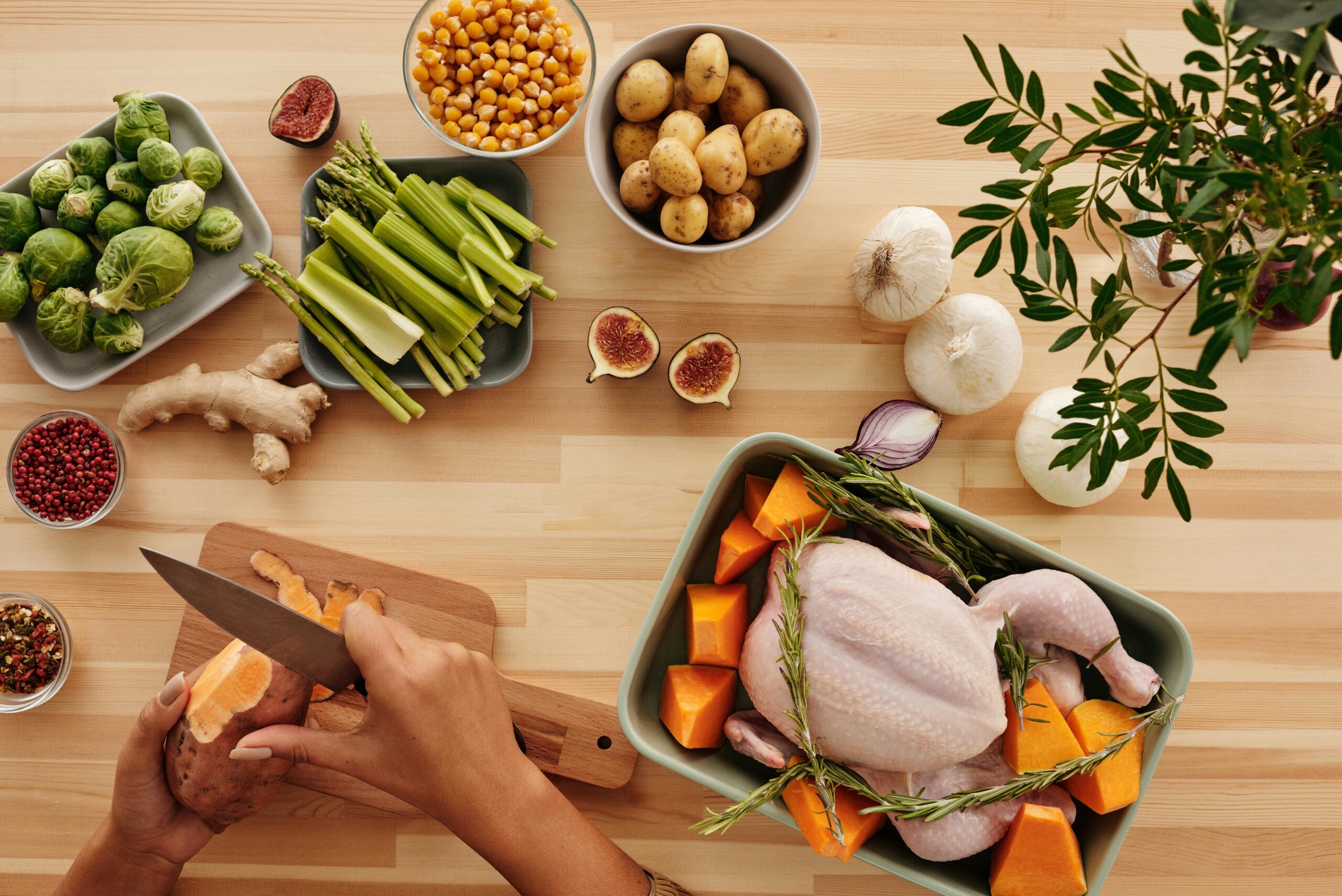 Top view of hands preparing ingredients for a roast with fresh vegetables.